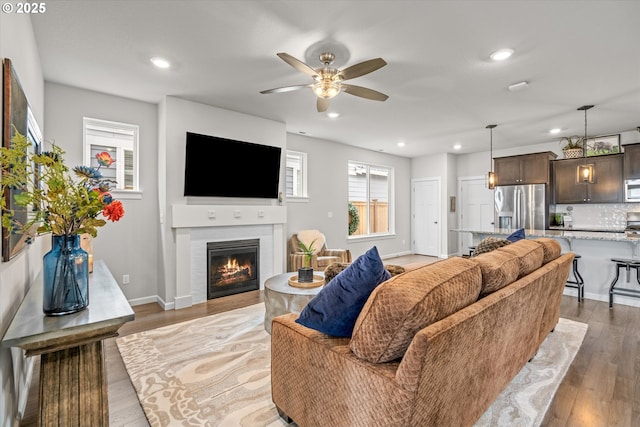 3477 SE Salmonfly Ln, Hillsboro, OR 97123 - living room featuring ceiling fan, light wood-style floors, recessed lighting, and a glass covered fireplace