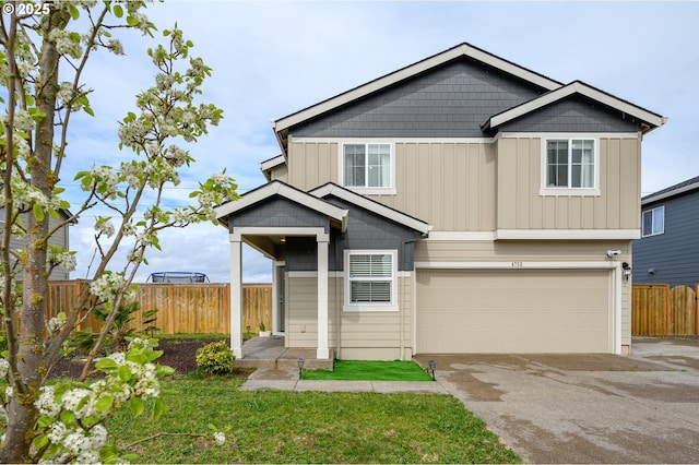 view of front of home with driveway, an attached garage, fence, and board and batten siding