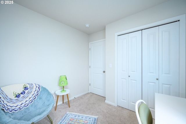 sitting room featuring light carpet and baseboards