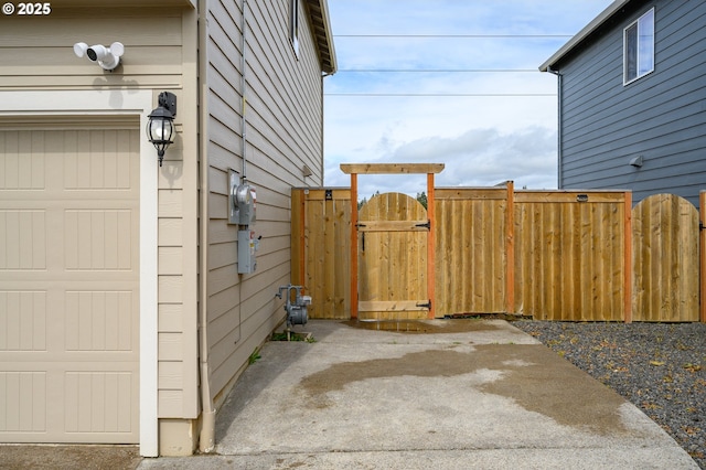 view of side of property with a garage, a gate, and fence