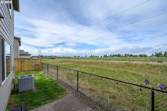 view of yard with fence, cooling unit, and a rural view