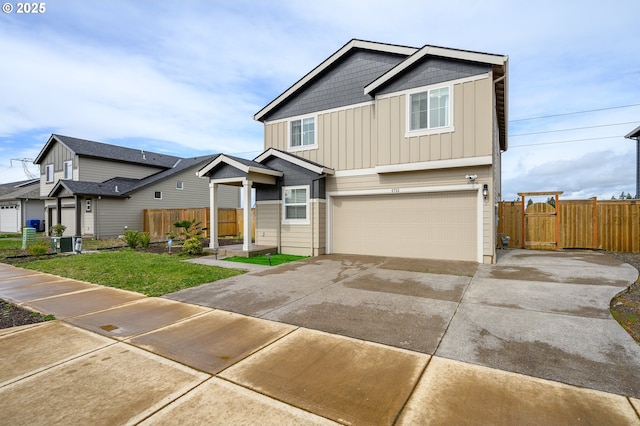 view of front of house with board and batten siding, fence, a garage, driveway, and a front lawn