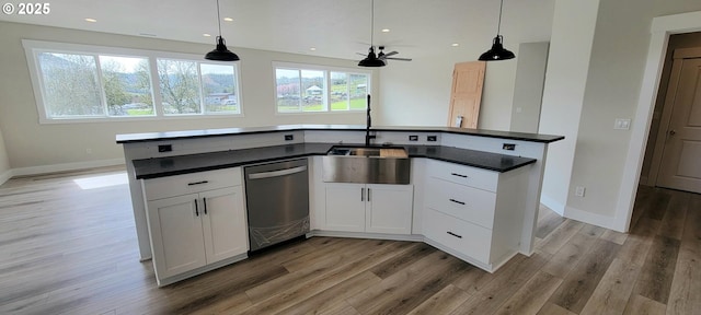 kitchen with dark countertops, light wood-style flooring, and dishwasher