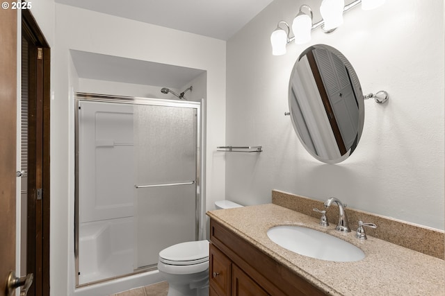 bathroom featuring walk in shower, vanity, toilet, and tile patterned flooring