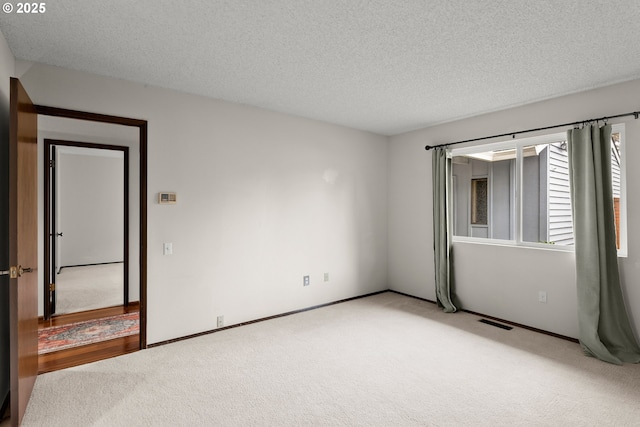 empty room featuring carpet flooring and a textured ceiling