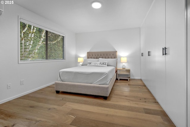 bedroom featuring wood finished floors and baseboards