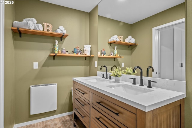 interior space featuring heating unit, a sink, baseboards, and double vanity