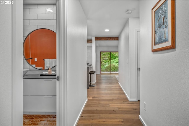 hallway featuring wood finished floors and baseboards