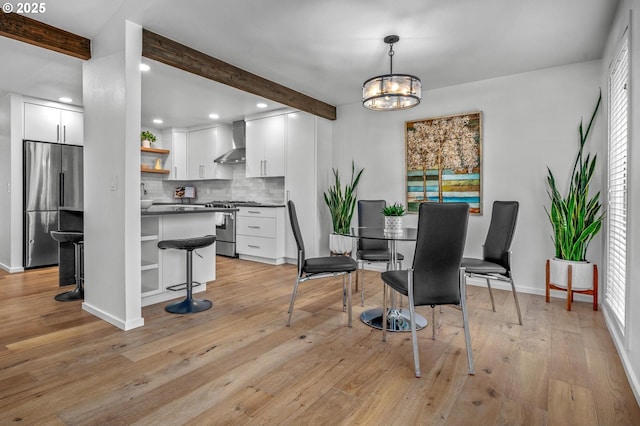 dining space with light wood-type flooring, a notable chandelier, baseboards, and beamed ceiling