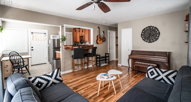 living room with ceiling fan and light wood-type flooring