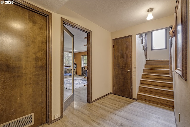 21445 NE Ornduff Rd, Hillsboro, OR 97123 - entryway featuring light wood-style floors, stairs, baseboards, and a textured ceiling