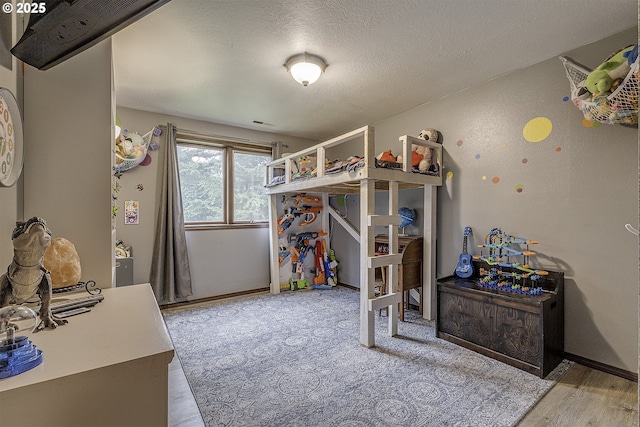 21445 NE Ornduff Rd, Hillsboro, OR 97123 - bedroom featuring wood finished floors, a textured ceiling, and baseboards