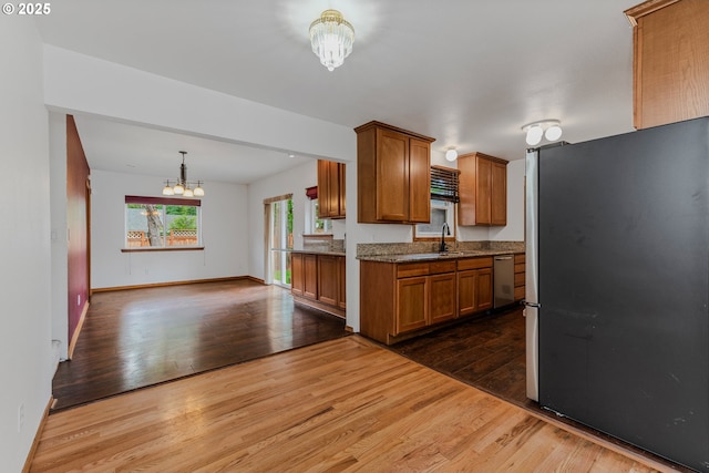3116 NE 108th Ave, Portland, OR 97220 - kitchen featuring appliances with stainless steel finishes, a chandelier, dark wood-style floors, a sink, and brown cabinets