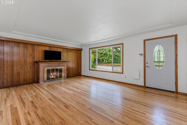 3116 NE 108th Ave, Portland, OR 97220 - unfurnished living room featuring light wood-style flooring, a brick fireplace, and baseboards