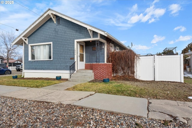 bungalow featuring a gate and fence