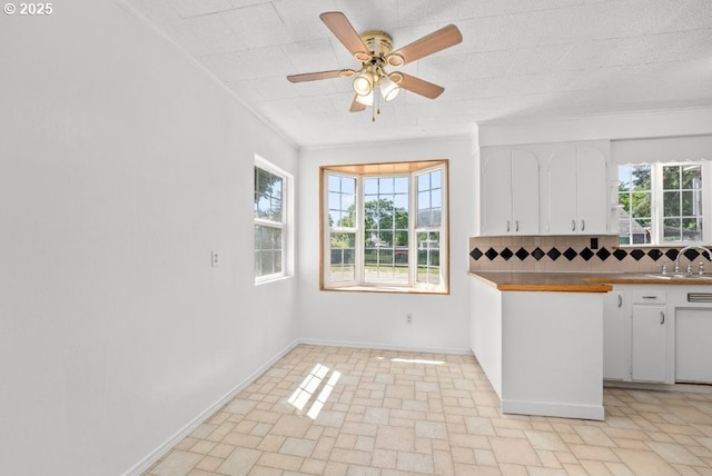 161 1st St, Dillard, OR 97432 - kitchen with white cabinetry, backsplash, a ceiling fan, plenty of natural light, and crown molding