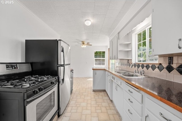 161 1st St, Dillard, OR 97432 - kitchen featuring gas range, a sink, ceiling fan, tasteful backsplash, and white cabinetry
