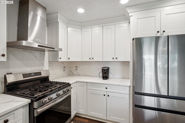 kitchen with stainless steel appliances, wall chimney exhaust hood, white cabinetry, backsplash, and light stone counters