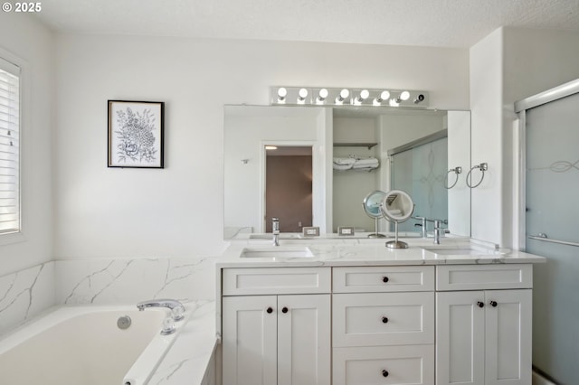 full bathroom featuring a stall shower, double vanity, and a bath