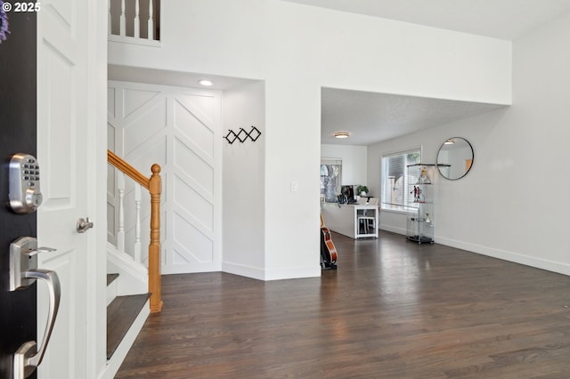 foyer with wood finished floors, baseboards, and stairs
