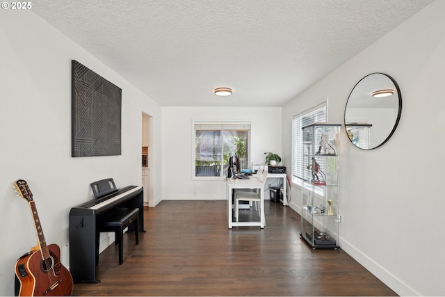 home office featuring dark wood-type flooring, baseboards, and a textured ceiling
