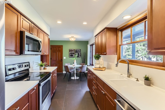 kitchen featuring appliances with stainless steel finishes, dark tile patterned flooring, and sink