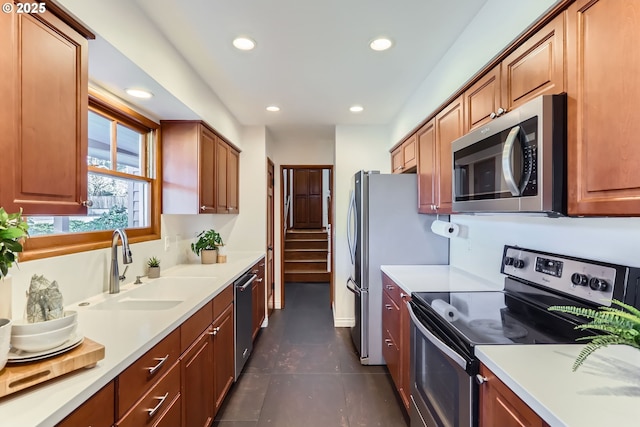 kitchen featuring appliances with stainless steel finishes, dark tile patterned flooring, and sink