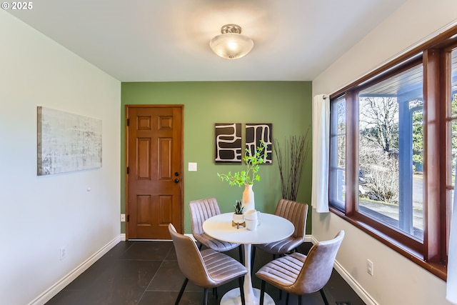 dining area featuring dark tile patterned floors