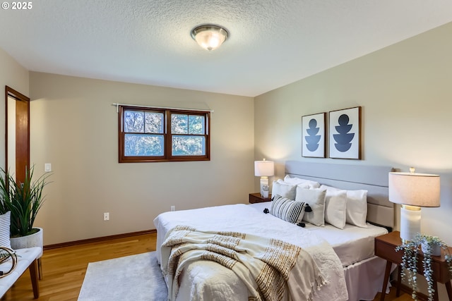 bedroom with light hardwood / wood-style flooring and a textured ceiling