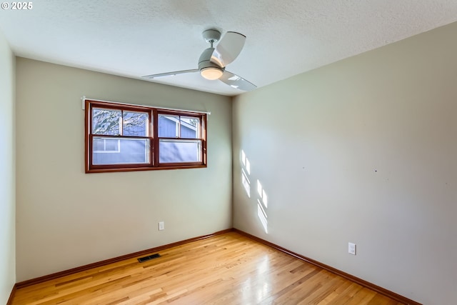 unfurnished room with ceiling fan, light hardwood / wood-style flooring, and a textured ceiling