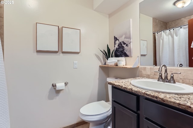 bathroom with vanity, toilet, and decorative backsplash