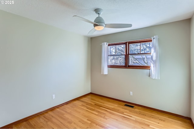 spare room featuring ceiling fan, light hardwood / wood-style floors, and a textured ceiling