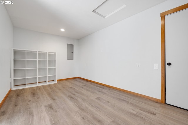 unfurnished room featuring electric panel and light hardwood / wood-style flooring