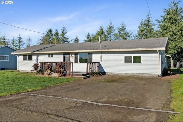 ranch-style home featuring a front lawn and a wooden deck