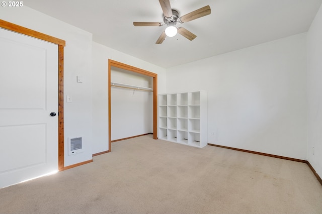 unfurnished bedroom with ceiling fan, heating unit, a closet, and light carpet