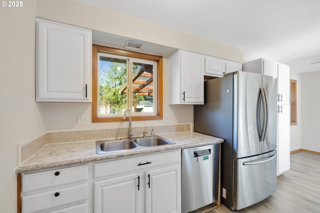 kitchen featuring light stone countertops, sink, white cabinets, and appliances with stainless steel finishes