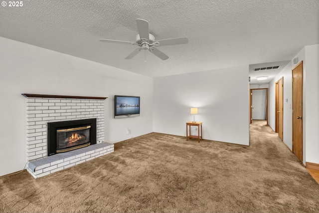 unfurnished living room with visible vents, carpet floors, a ceiling fan, and a fireplace