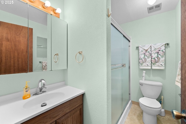 bathroom featuring vanity, baseboards, visible vents, a shower stall, and toilet