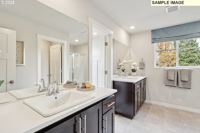 full bath with visible vents, recessed lighting, a shower stall, and a sink