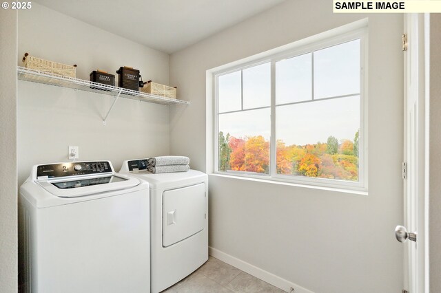laundry area featuring washer and dryer, baseboards, laundry area, and a healthy amount of sunlight