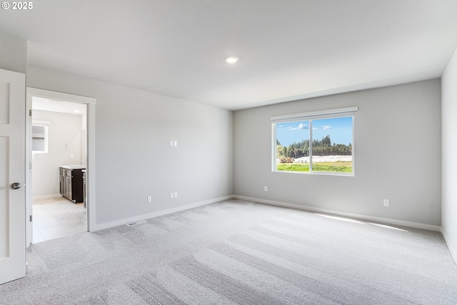 unfurnished room with visible vents, baseboards, recessed lighting, and light carpet