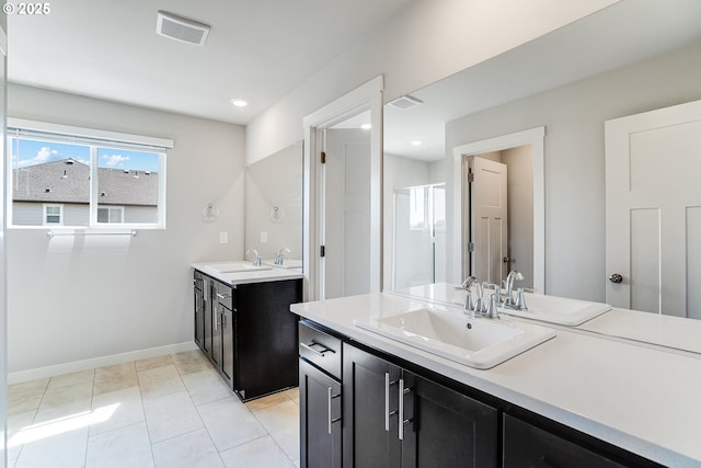 full bathroom with two vanities, visible vents, baseboards, and a sink