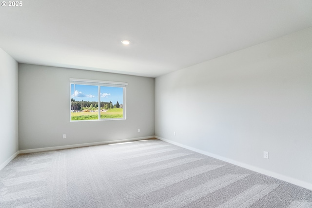 empty room with recessed lighting, light carpet, and baseboards
