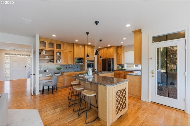 23680 SW Robson Ter, Sherwood, OR 97140 - kitchen featuring stainless steel appliances, a center island, a kitchen bar, light wood-style floors, and recessed lighting