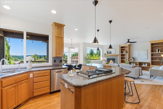 23680 SW Robson Ter, Sherwood, OR 97140 - kitchen with appliances with stainless steel finishes, a kitchen island, light wood-type flooring, a kitchen breakfast bar, and open floor plan