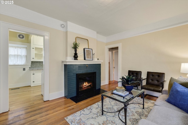 5851 NE 12th Ave, Portland, OR 97211 - living area with light wood-style flooring, a brick fireplace, and baseboards