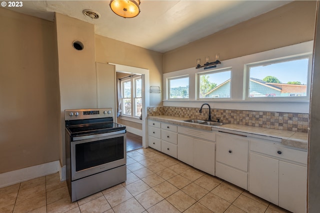 kitchen featuring white cabinets, a sink, light countertops, electric stove, and backsplash