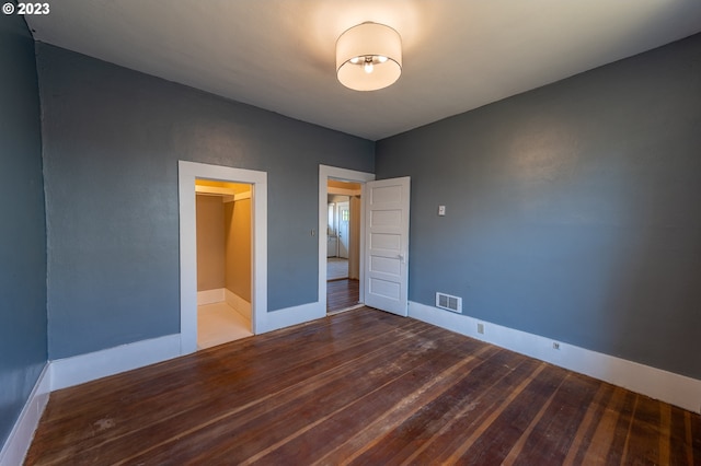 unfurnished bedroom featuring visible vents, wood finished floors, and baseboards