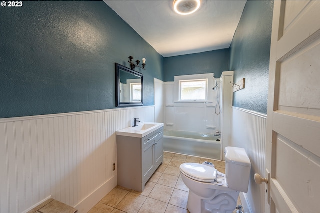 full bath with toilet, vanity, a wainscoted wall, and tile patterned floors