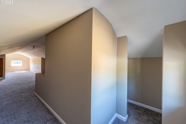 interior space with baseboards, carpet, and vaulted ceiling